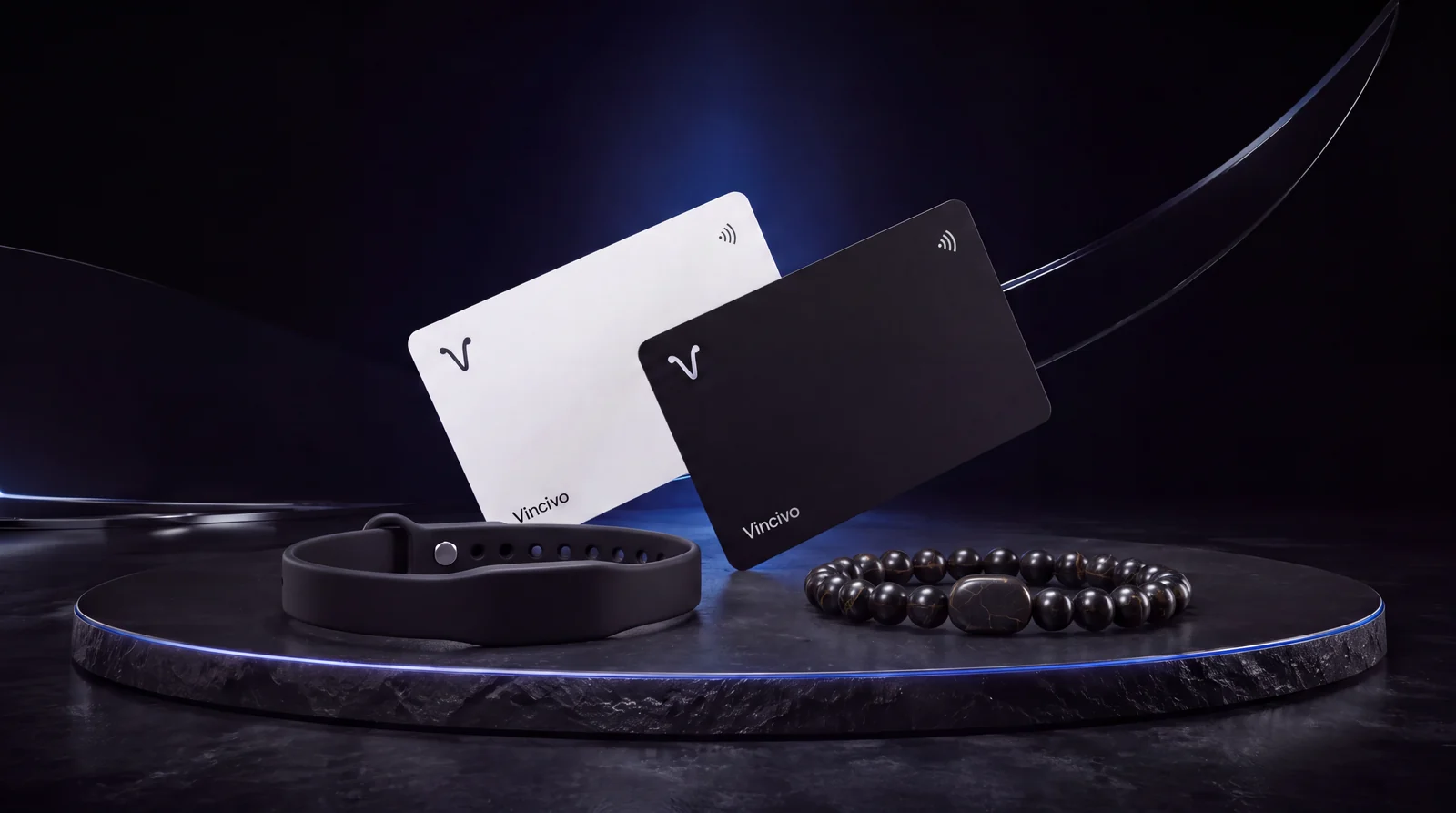 Vincivo collection visualization: black and warm-white cards, the adjustable black silicone NFC bracelet, and the Coconut stone-bead concept on a black stone platform with blue studio lighting.
